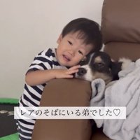 犬の隣で笑顔を見せる子ども