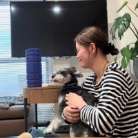 犬を見て笑顔になる女性