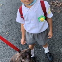 登園前の服装で犬と並んでいる子ども