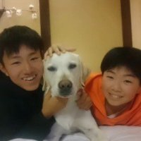 横に並んで笑顔の犬と2人の男の子