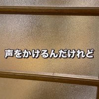 ドアの向こうでお座りをする犬