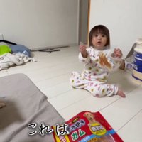 飼い主におやつの袋を見せる女の子