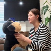 犬のぬいぐるみを持つ女性