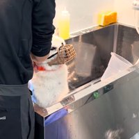 シャンプー台の中で体を拭かれる犬