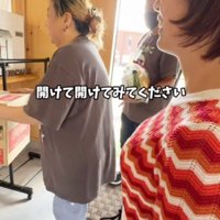 女将にダンボールを差し出す客