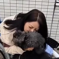 女性にギュッと抱きしめられる犬