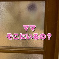 ドアの向こうでソワソワした様子を見せる犬