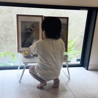 しゃがんで遺影を見つめる子ども