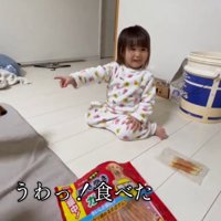 おやつを持っていた犬を見て笑顔になる女の子