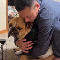 犬を背中側から抱きしめる男性