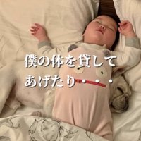 赤ちゃんの下で眠る犬