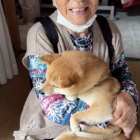 犬を抱えて笑う人
