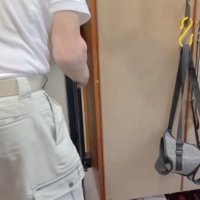 玄関に取り付けたロールカーテンをひっぱるおじいちゃん