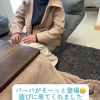 こたつの前で微笑む人