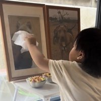 優しく遺影を拭く子ども