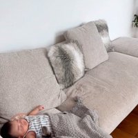 ソファでくっついて横になっている犬と赤ちゃん