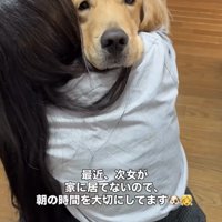女の子の肩に顔を乗せる犬