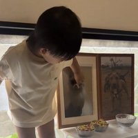 立って遺影を見つめる子ども
