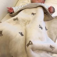 ブランケットの中で手足を動かす赤ちゃん