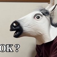 馬の被り物を着けて犬に話しかける飼い主