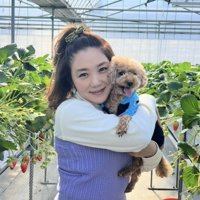 いちご畑で犬を抱く女性