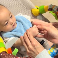おやつを持っている赤ちゃんの手を優しく支える飼い主