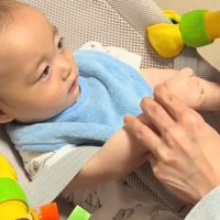 おやつを食べた犬を目で追う赤ちゃん