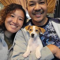 犬を囲んで笑顔で写真を撮る家族