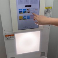 プリクラの機械を操作する飼い主