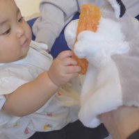 パペットにおやつを渡す赤ちゃん
