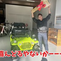 ミニカーの前で笑顔の男性