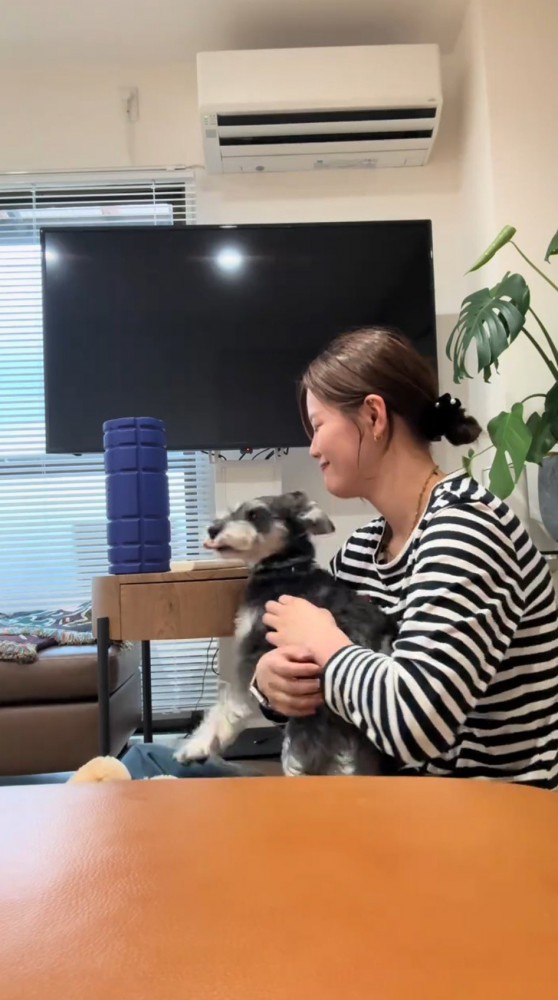 犬を見て笑顔になる女性