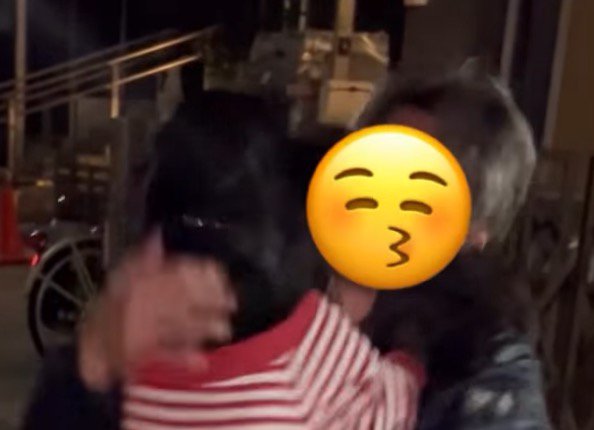 黒い犬の頭を撫でる男性