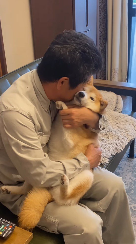 犬に頬ずりする男性