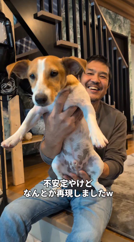 犬を抱き上げる男性