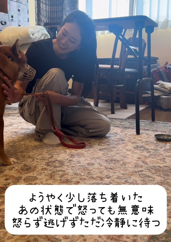 落ち着き始めた犬と静かに寄り添う女性