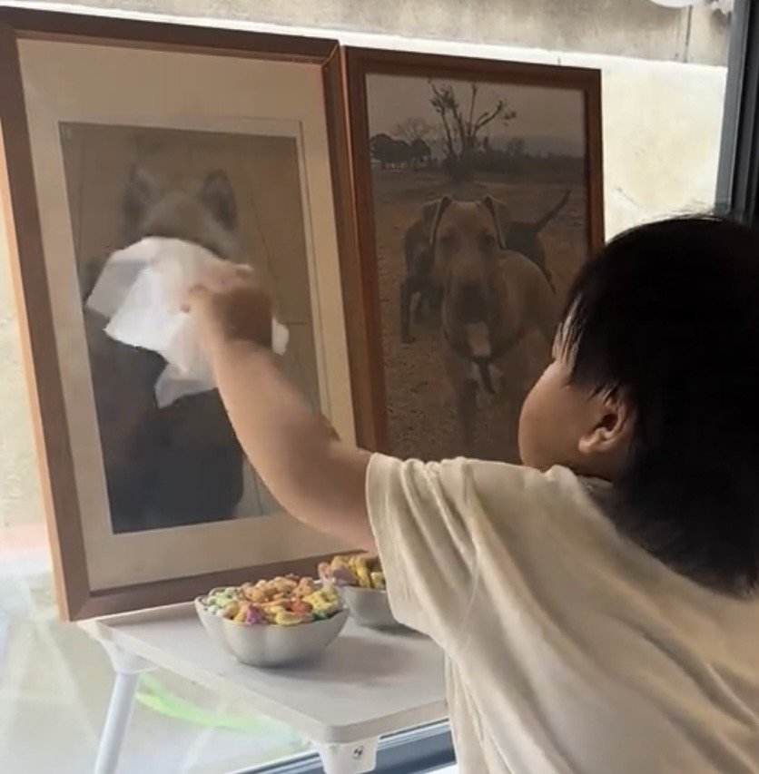 優しく遺影を拭く子ども