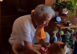 犬の体に手を回して抑える老年男性