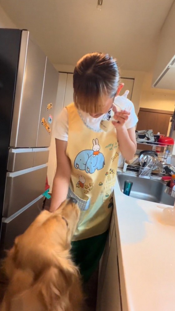 哺乳瓶を頬に当てる飼い主