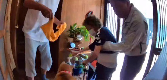 家の中に上がろうとする老年女性と、それを見守る犬