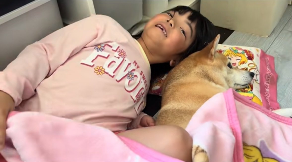 柴犬と添い寝する女の子