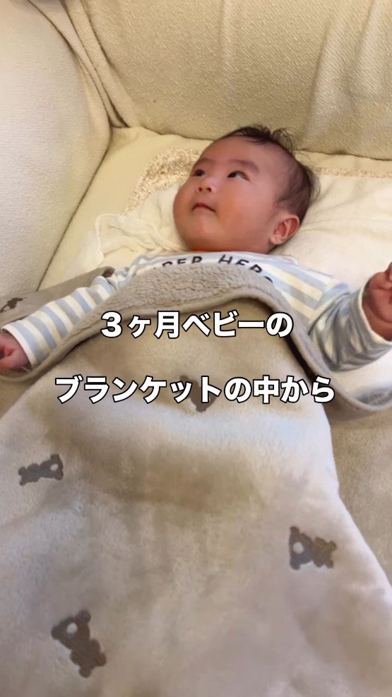 横になってブランケットをかけられている赤ちゃん