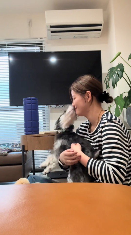 女性の口を舐める犬