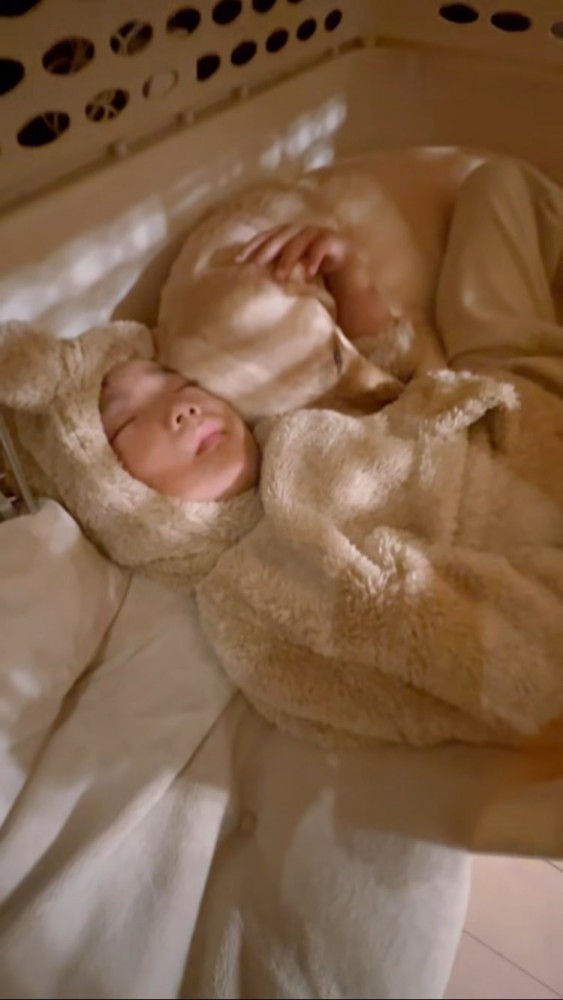 クレートの中で寄り添って眠る犬と男の子アップ