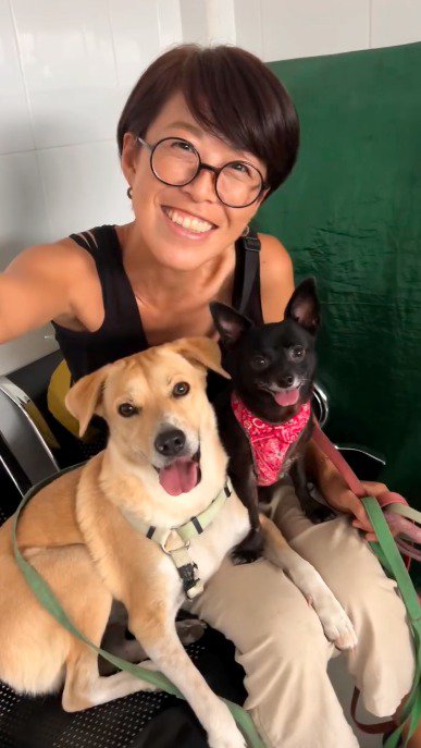 カメラに向かって笑顔を見せる飼い主と犬