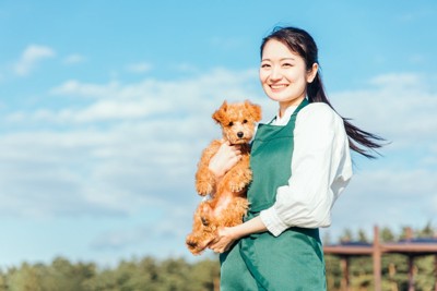 犬を抱っこする女性