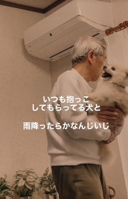 おじいちゃんに抱っこされている小型犬