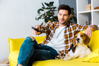 テレビを見ている男性と犬