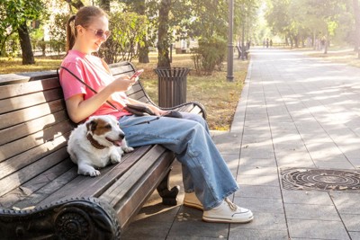ベンチに座ってスマホ見る