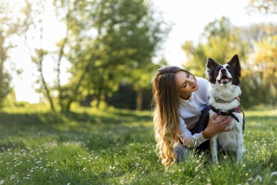 草むらにいる犬と女性